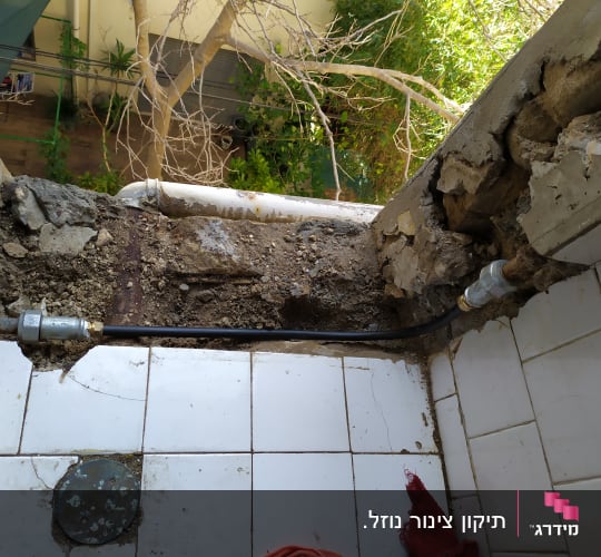 צינור מים ותשתית חשופה בקיר שבור
